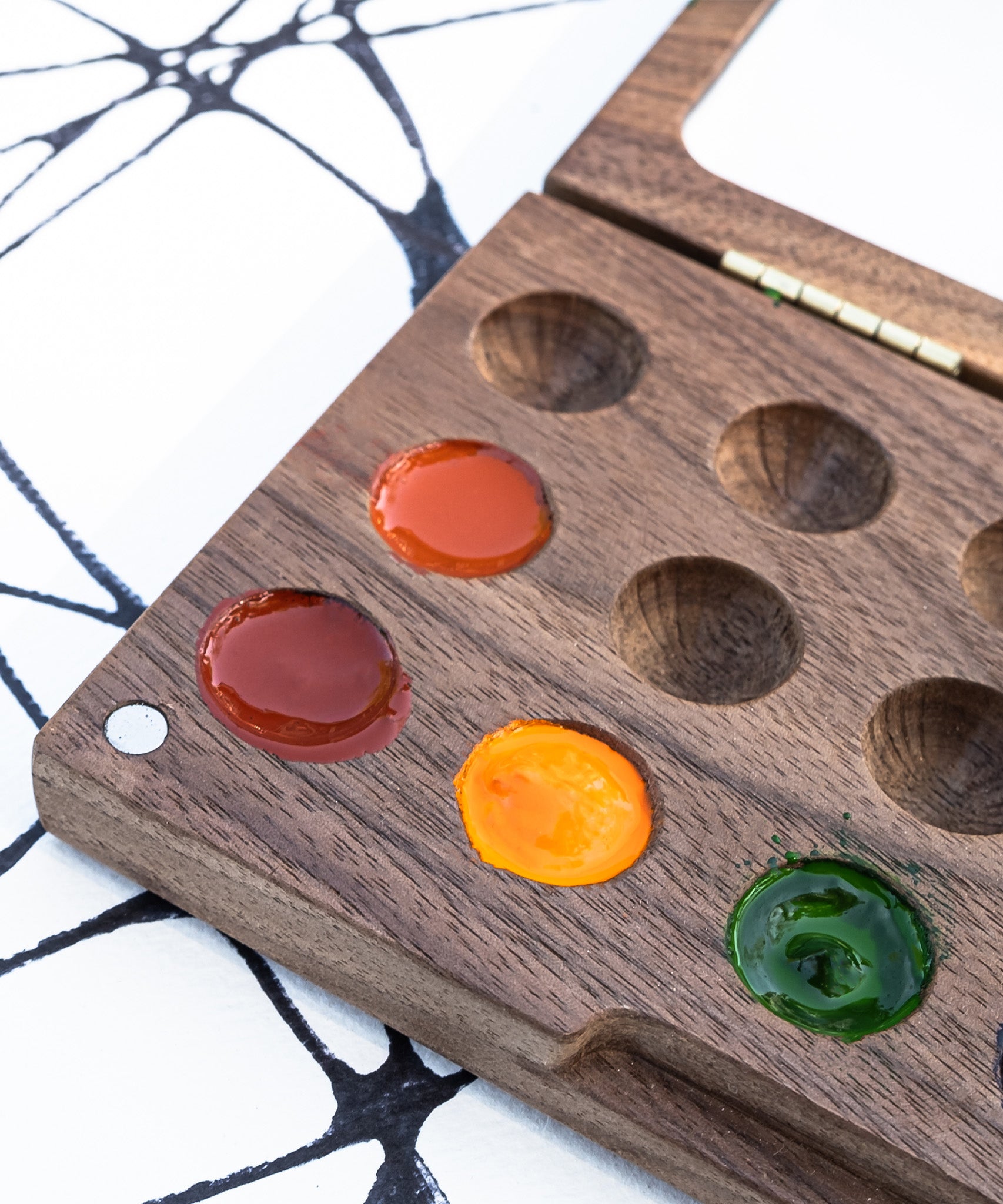 A close up of the Natural Earth Paint small wooden watercolour palette showing different coloured paint in the well