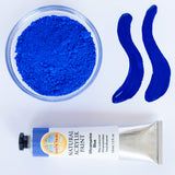 A top down view of the Natural earth paint in ultramarine blue next to the blue pigment powder and 2 streaks showing the consistency.