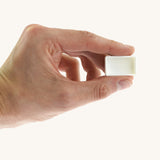 An adult hand holding the white blank watercolour paint pan from Natural Earth Paint  for size reference.