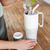 A close up of a white tofu coloured Klean Kanteen Limited Edition 36oz Rise Tumbler placed on a wooden counter top