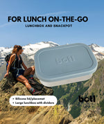 A One Green Bottle lunchbox in soldier colour with a mountain range in the background. A stainless steel plastic free lunchbox available at Bapipur. Features a pale blue silicone lid, perfect for lunch on the go