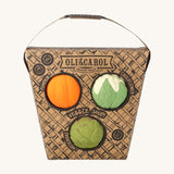 Oli & Carol Vegetable soup Baby Sensory Balls in their basket shaped cardboard packaging, a pumpkin, cauliflower and an artichoke.