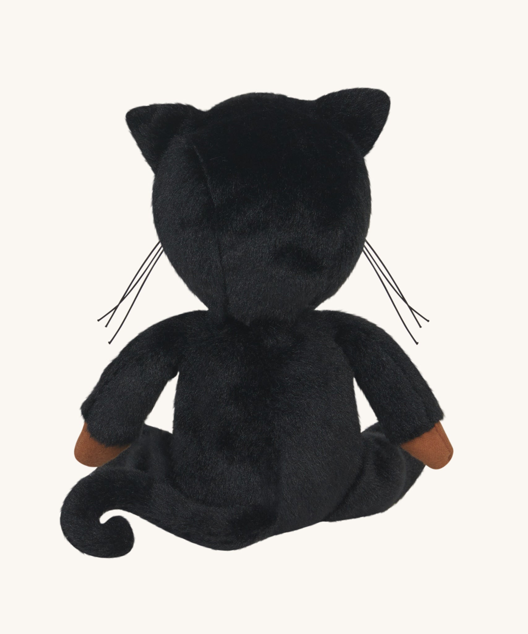 The back of an Olli Ella Carson Cat Dinky Dinkum Doll. This soft toy is a black cat with glow in the dark inner ears and a small embroidered rainbow detail on the chest. These soft toys are part of Olli Ella's Halloween collection available here at Babipur.