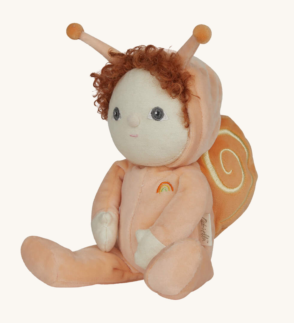 The Olli Ella Dinky Dinkum Doll - Scottie Snail - in a soft light orange onesie with curly red hair, a snail shell on his back, and antennae.