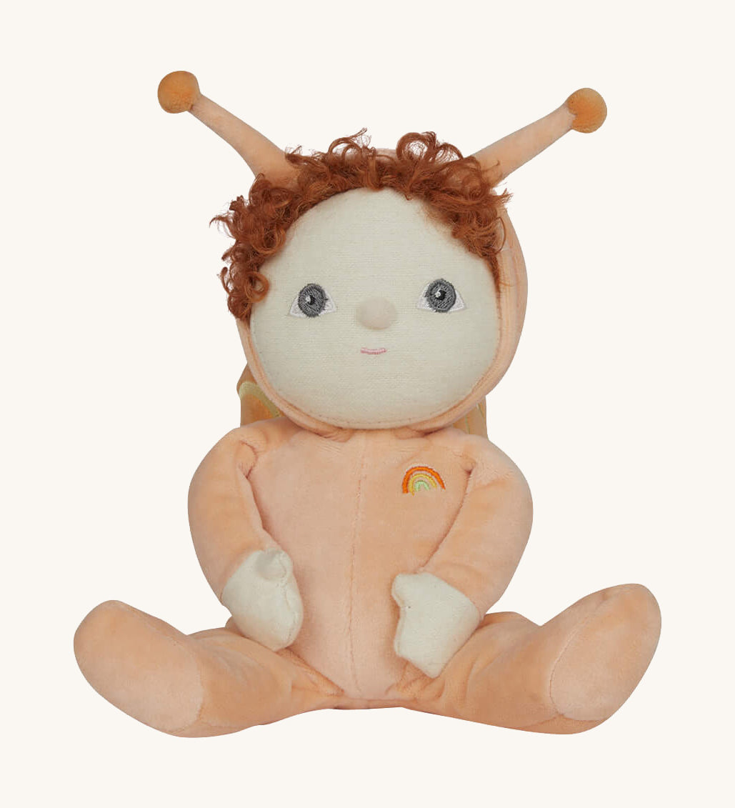 The Olli Ella Dinky Dinkum Doll - Scottie Snail - in a soft light orange onesie with curly red hair, a snail shell on his back, and antennae.