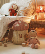 The Olli Ella Dozy Dinkum Doll - Toadstool Pip. It is in a bedroom with a mushroom rattan doll's house basket.