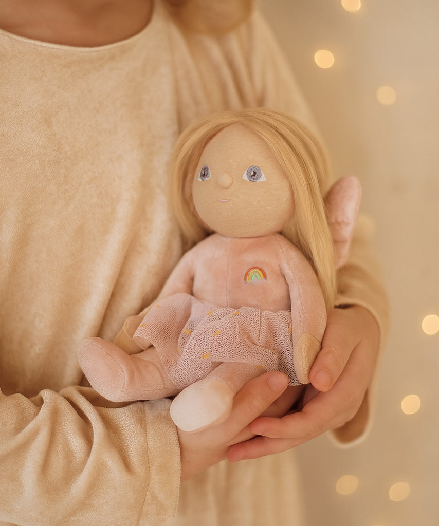A child clutching the Olli Ella Fiona fairy dinky dinkum doll available at Babipur.