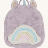 A lilac Olli Ella fluffy unicorn backpack with a rainbow on the front on a cream background.