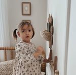 The Olli Ella Rattan Daisy Wall Basket in Natural Rattan on the wall