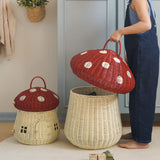 A child taking off the spotty mushroom lid of the red Olli Ella toadstool basket.