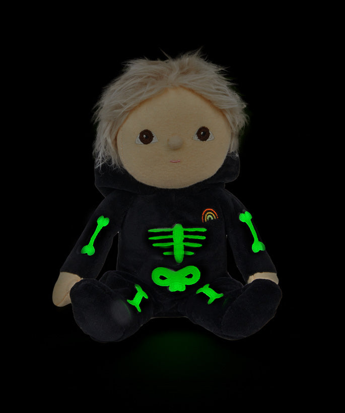 Olli Ella Scully Skeleton Dinky Dinkum Doll soft toy. The doll features glow in the dark bone details on the front along with a small embroidered rainbow on the chest. These soft toys are part of Olli Ella's Halloween collection available here at Babipur.