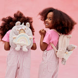2 kids wearing the pink and lilac Olli Ella backpacks with dinky dinkum dolls on the back.