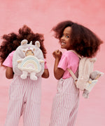 2 kids wearing the pink and lilac Olli Ella backpacks with dinky dinkum dolls on the back.