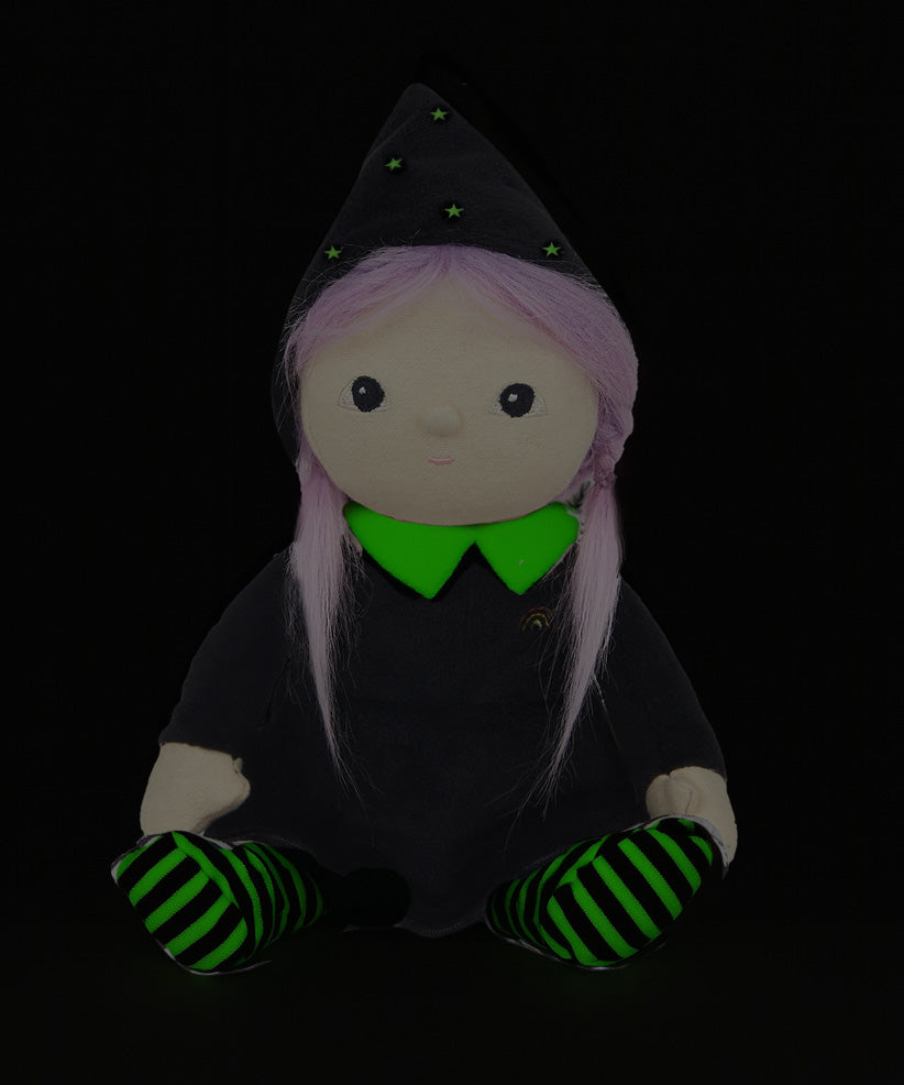 Olli Ella Willa Witch Dinky Dinkum Doll. A witch with a black outfit and matching hat with glow in the dark features on the striped tights, collar and stars on the hat. These soft toys are part of Olli Ella's Halloween collection available here at Babipur.