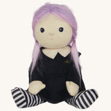 An Olli Ella Willa Witch Dinky Dinkum Doll shown with it's hat off. A witch with a black outfit and matching hat with glow in the dark features on the striped tights, collar ans tars on the hat. These soft toys are part of Olli Ella's Halloween collection available here at Babipur.