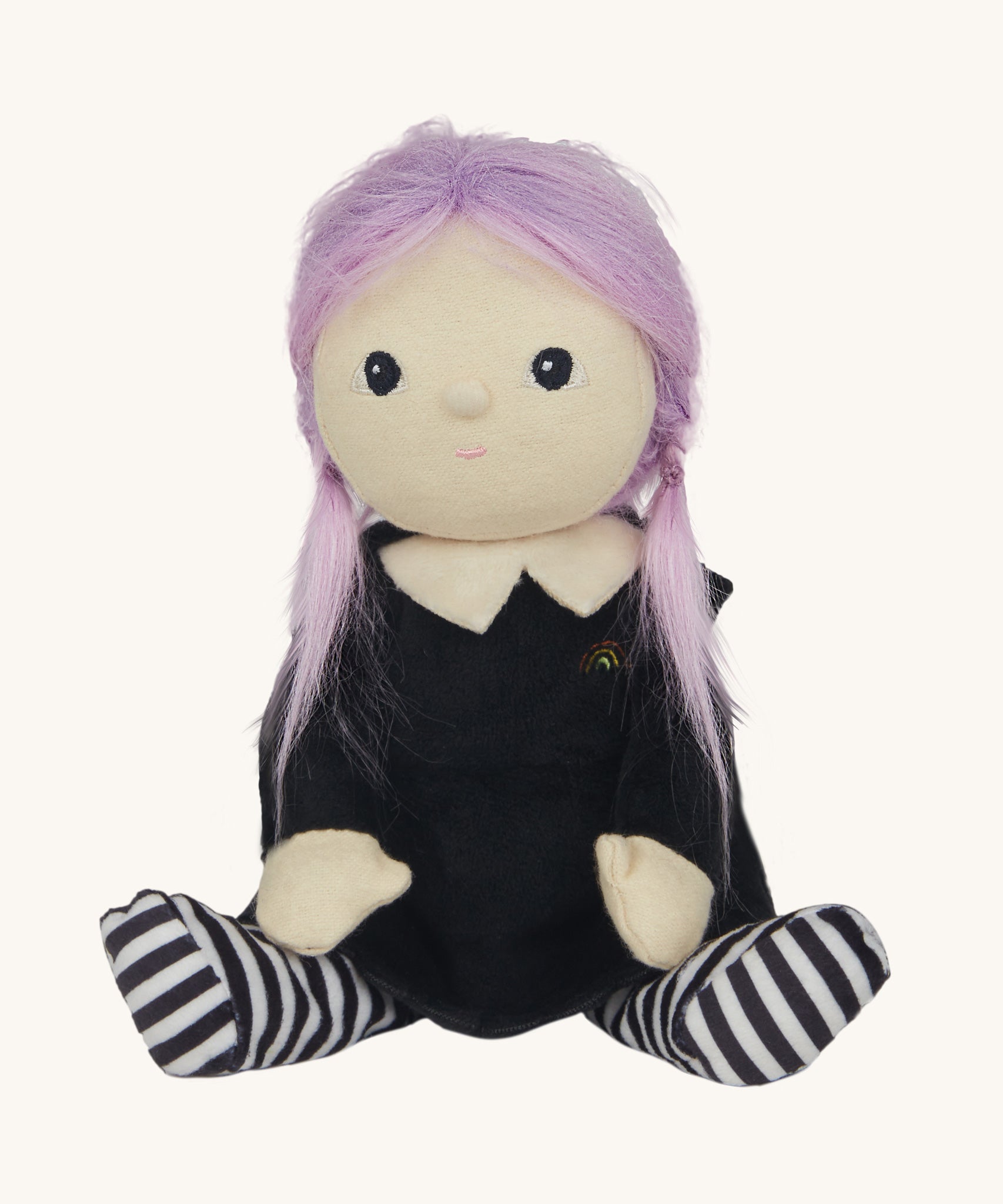 An Olli Ella Willa Witch Dinky Dinkum Doll shown with it's hat off. A witch with a black outfit and matching hat with glow in the dark features on the striped tights, collar ans tars on the hat. These soft toys are part of Olli Ella's Halloween collection available here at Babipur.