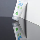 A tube of Organic Babies Baby Wash & Shampoo Scent Free placed on a mirrored surface.