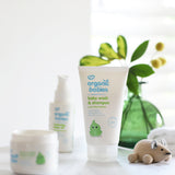 Organic Babies Baby Wash & Shampoo Scent Free placed on a white surface next to a wooden toy mouse. Other products from the organic babies collection can be seen in the background.