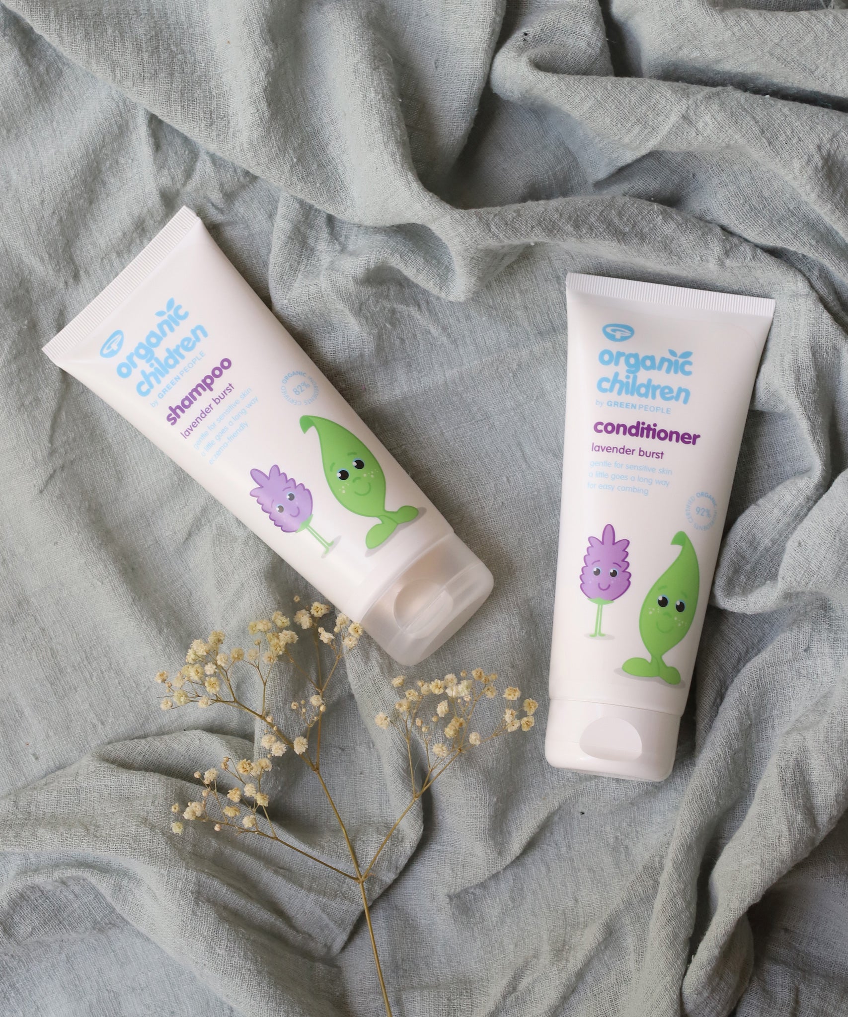Organic Children Lavender Burst Shampoo and conditioner on a piece of moss green coloured linen.