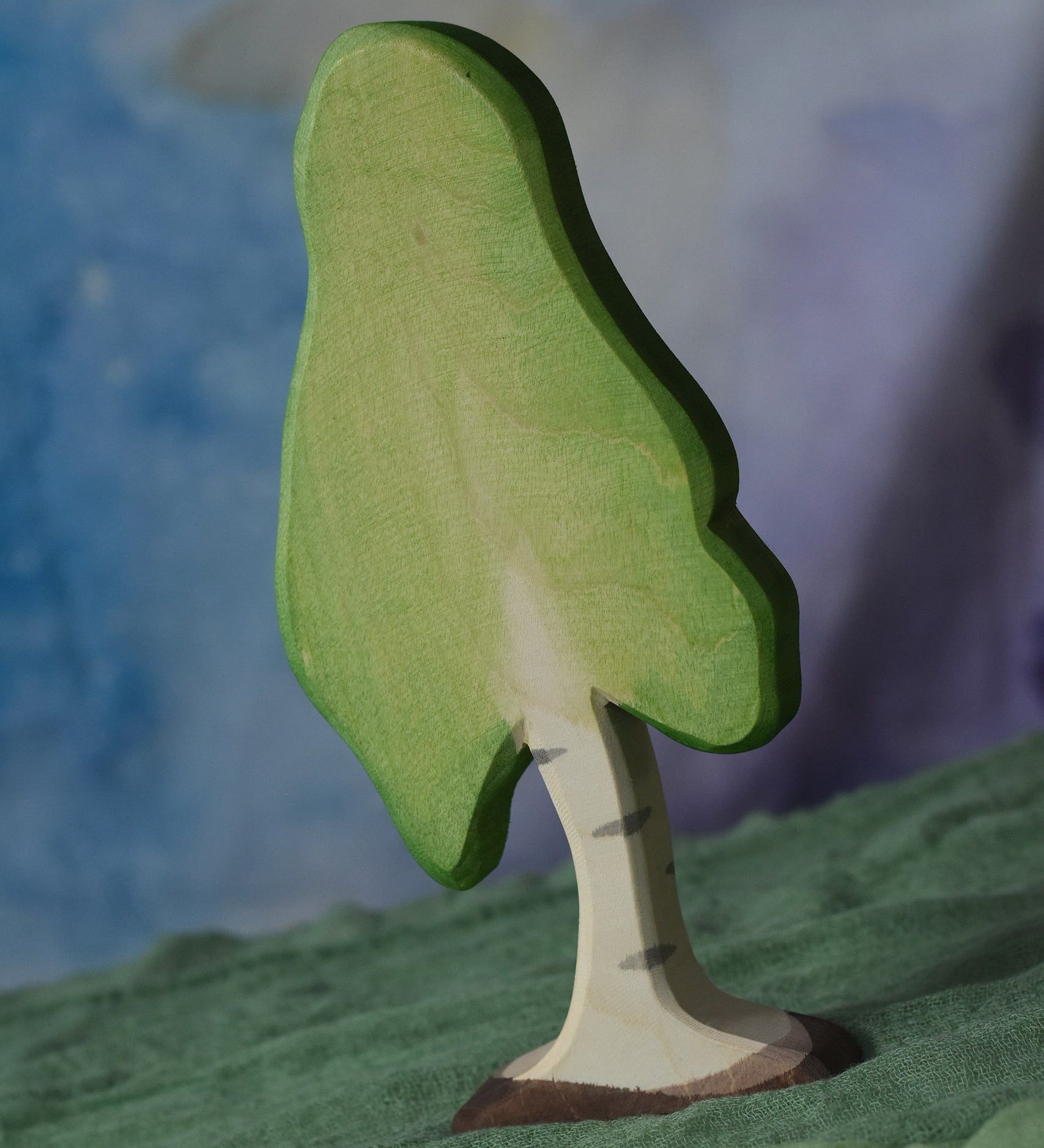 A large Ostheimer birch tree placed on a green coloured Ostheimer decoration scarf. This wooden figure is part of a large range of expertly hand crafted, Waldorf inspired, wooden toys here at Babipur.
