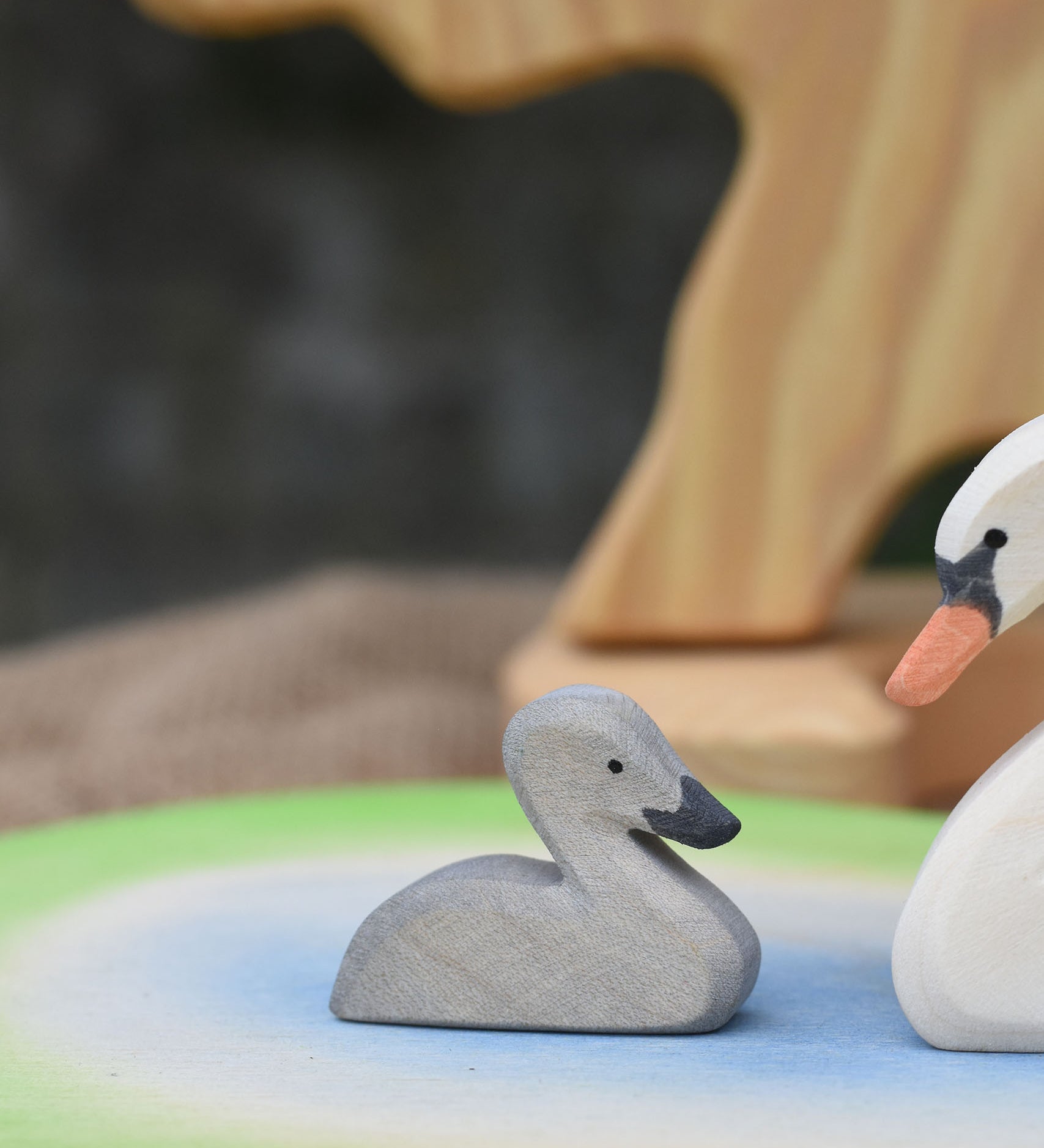 An Ostheimer grey coloured cygnet placed on a pond scene piece.