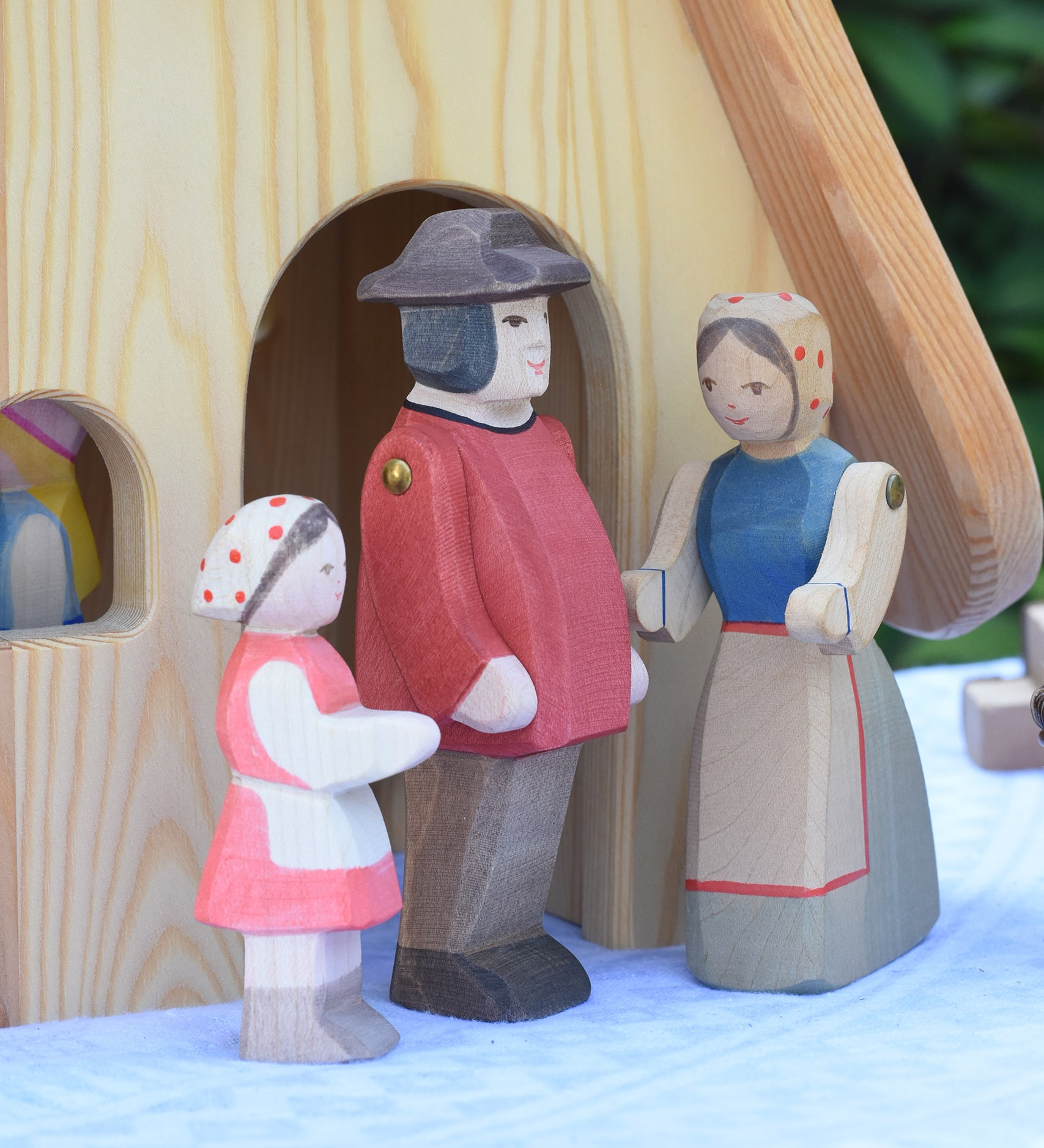 Ostheimer Heidi and male and female farmer figures placed in front of the Fairy Tale cottage. These wooden figures are part of a large range of expertly hand crafted, Waldorf inspired, wooden toys here at Babipur.