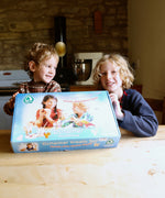 Two children smiling and holding up the Ostheimer paint your own creative set. The set is in it's packaging.