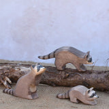 Three Ostheimer wooden toy raccoon figures placed in a simple small world play scene. Check out our full range of expertly crafted wooden toy figures and scenery here at Babipur.