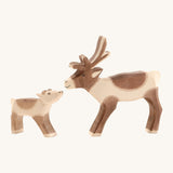 A ostheimer reindeer figure standing next to a wooden Ostheimer reindeer calf on a cream background.
