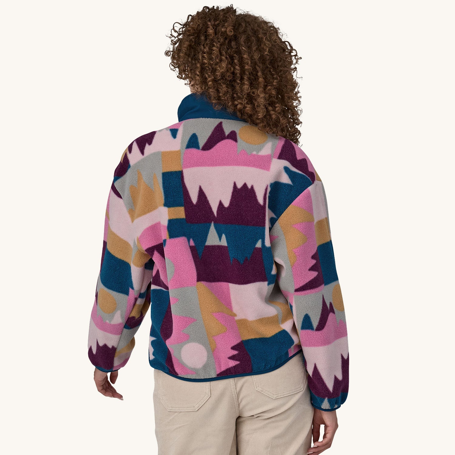 A woman models the back of the Patagonia Women's Synchilla Fleece Jacket - Frontera / Marble Pink.
