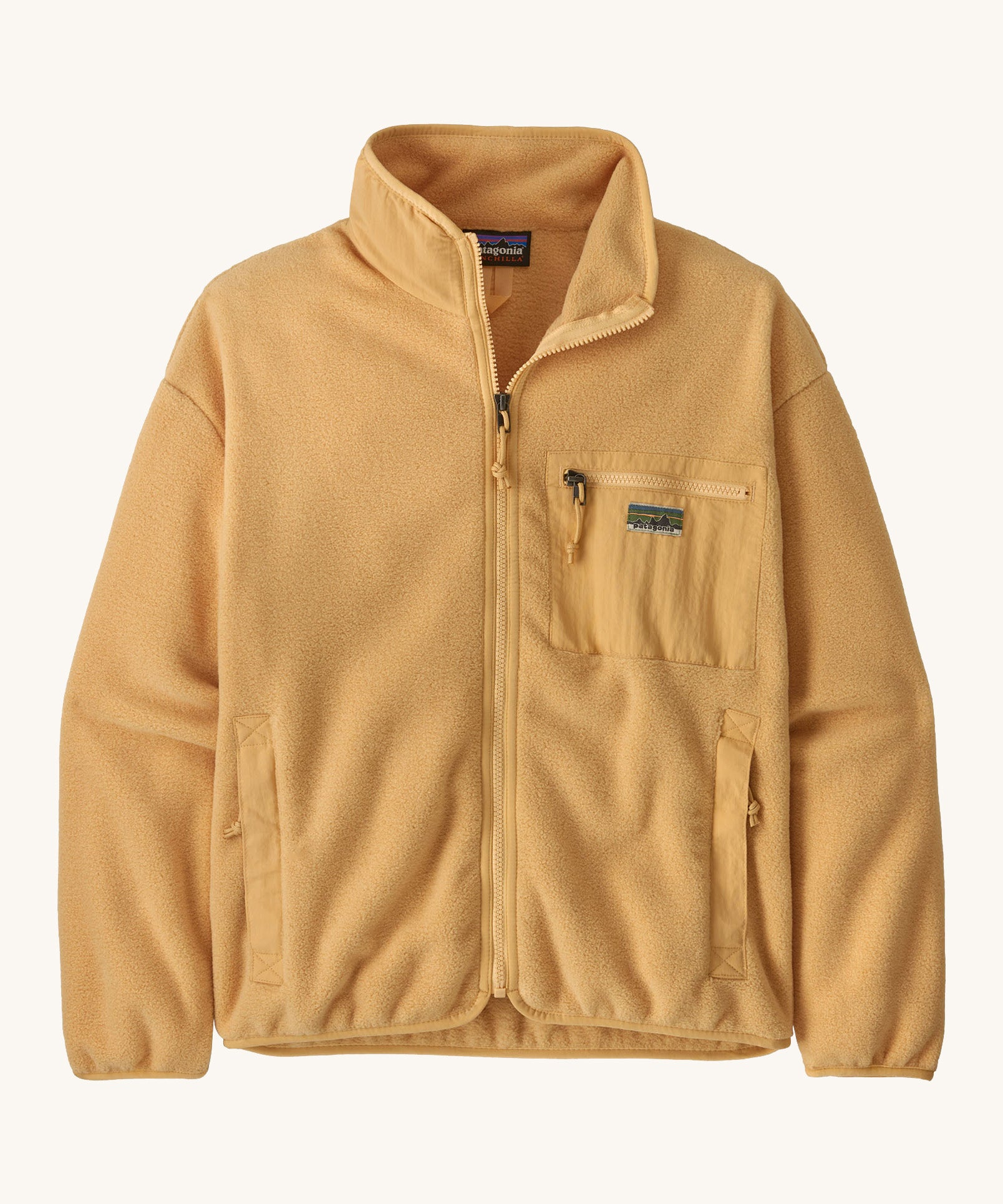 Patagonia synchilla fleece in a beeswax tan colour on a cream background.