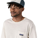 Patagonia airfarer cap in a birch white colour and Chouinard crest design worn by an adult