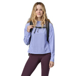 A woman wearing The Patagonia Black Hole Pack 32 litre capacity backpack in smolder slate-blue