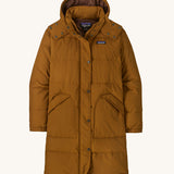 Patagonia parka in a brown colour on a cream background.