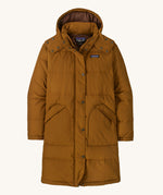 Patagonia parka in a brown colour on a cream background.