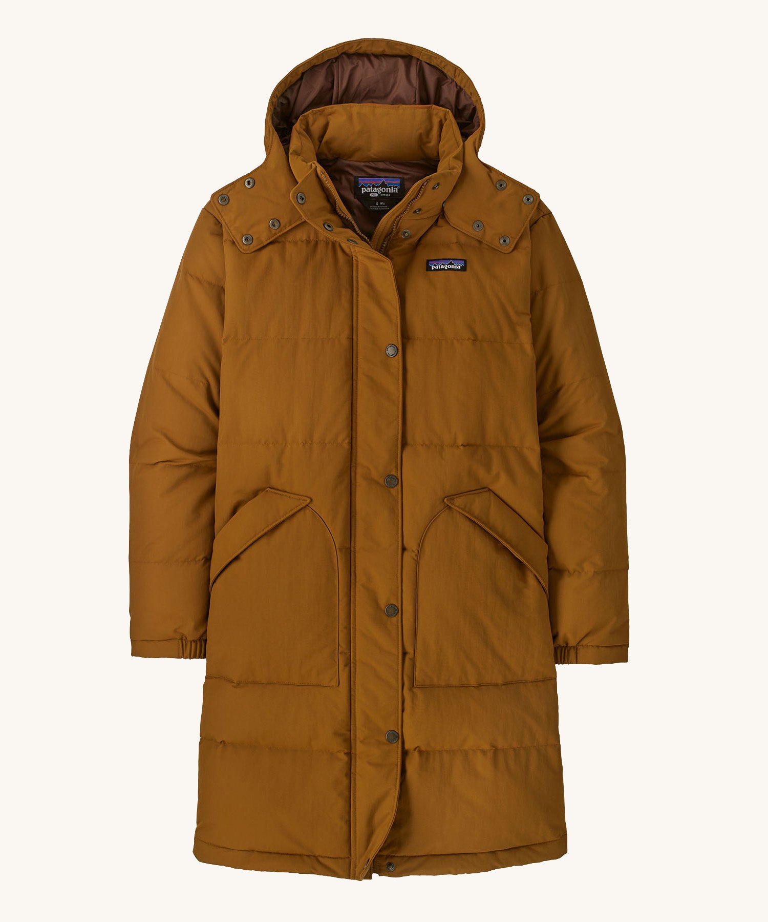 Patagonia parka in a brown colour on a cream background.