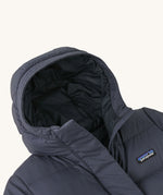 A close up of the hood on the Patagonia Kids Silent Down Parka in a Smolder Blue colour on a plain background.