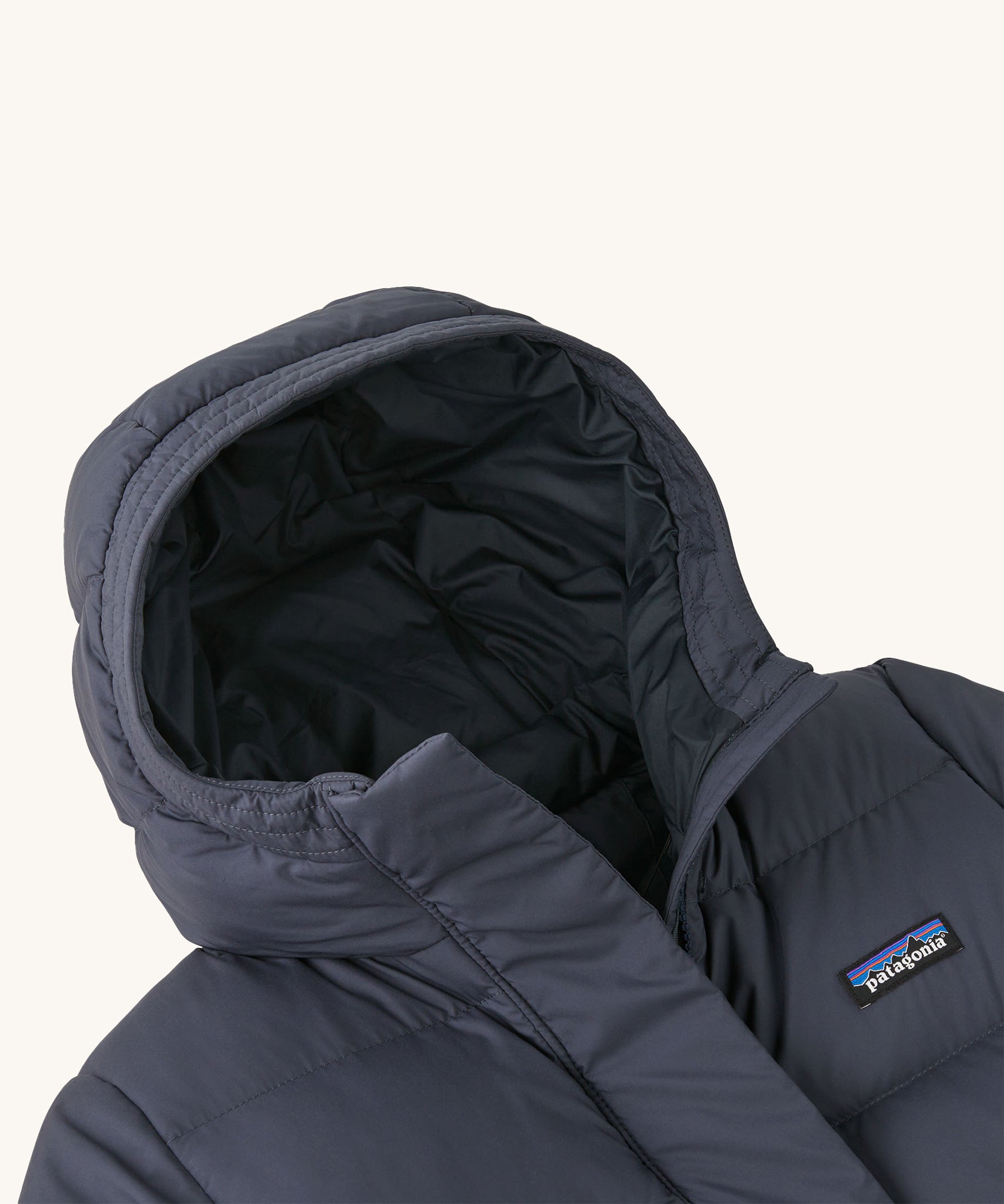 A close up of the hood on the Patagonia Kids Silent Down Parka in a Smolder Blue colour on a plain background.