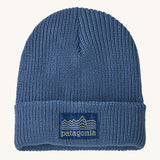 Patagonia kids beanie. A ribbed style hat in blue with the pastel yellow pencil style logo patch stitched on the turned up brim.