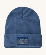 Patagonia kids beanie. A ribbed style hat in blue with the pastel yellow pencil style logo patch stitched on the turned up brim.