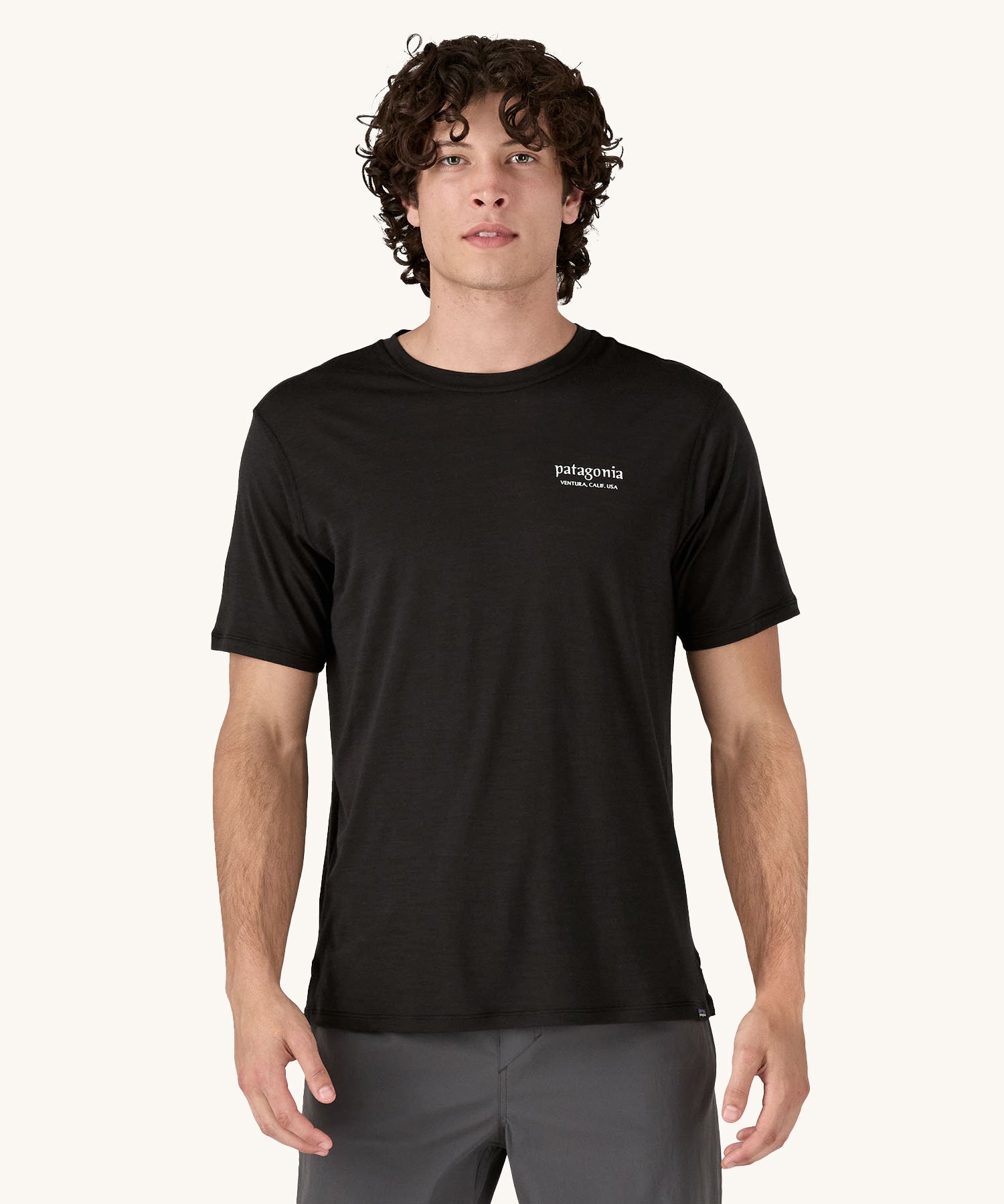 A man wearing the Patagonia Men's Capilene Cool Merino Graphic Shirt with a Heritage Header design in Black.