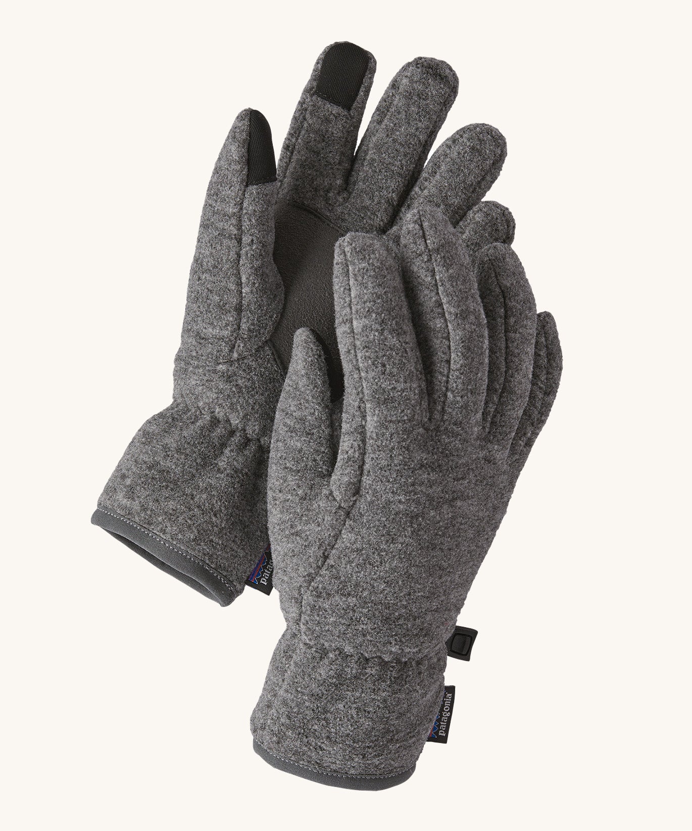 Close up of the Patagonia kids synchilla gloves clipped together for easy carrying showing the grip panel on the palm, thumb and index finger.  Logo patch stitched on the wrist cuff.