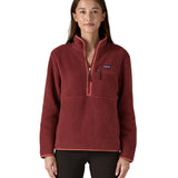 A woman wearing the Patagonia sequoia red marsupial retro fleece showing front trim and zip detail