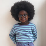 A child wearing the Pigeon Organics long sleeve top showing the light and dark blue striped design on organic cotton fabric