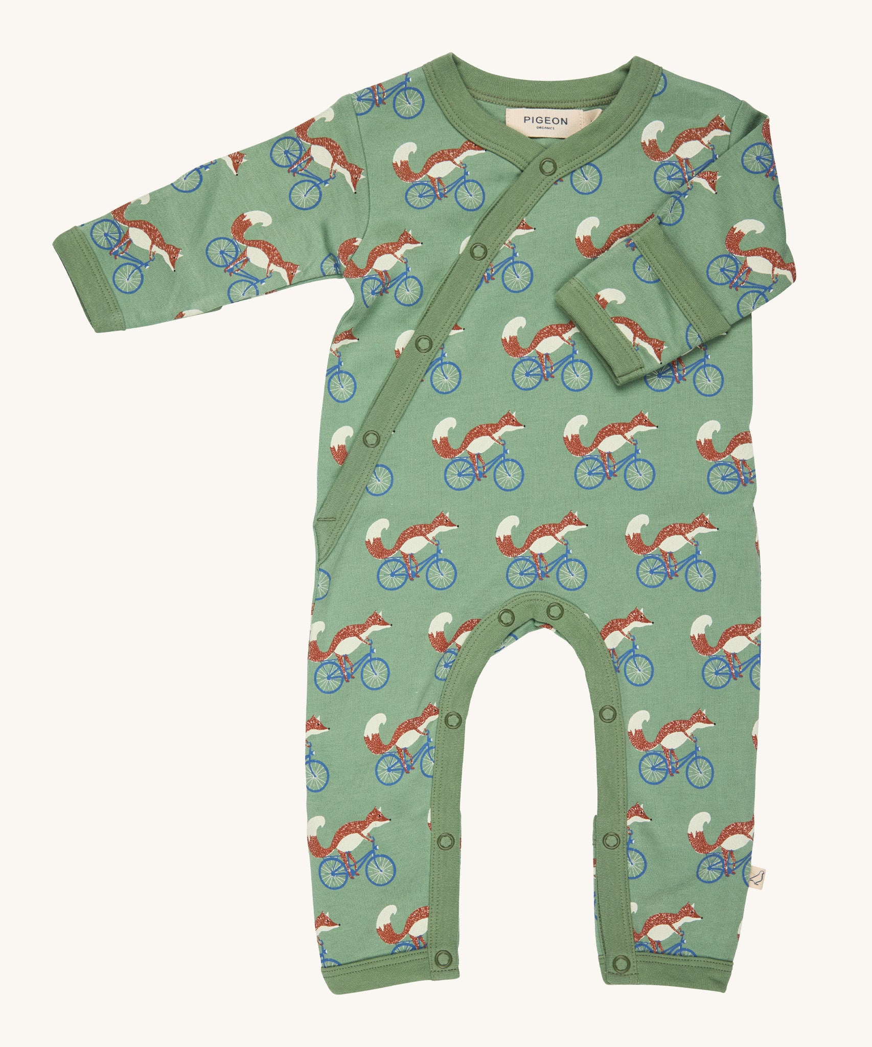 Pigeon Organics kimono romper. A 100% GOTS organic cotton in pale green with long sleeves and popper fasteners at the front and between the legs. Features a print of a cycling fox all over the garment.