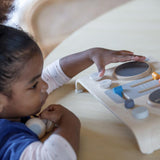 Plan Toys DJ Mixer Board Wooden Toy being carried by child in front of steps outside with toy headphones