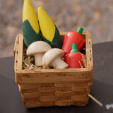 Plan Toys Wooden Produce Set - play food vegetables including Corn on the cob, Mushrooms and Red Peppers shown in a basket in a play kitchen.
