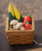 Plan Toys Wooden Produce Set - play food vegetables including Corn on the cob, Mushrooms and Red Peppers shown in a basket in a play kitchen.