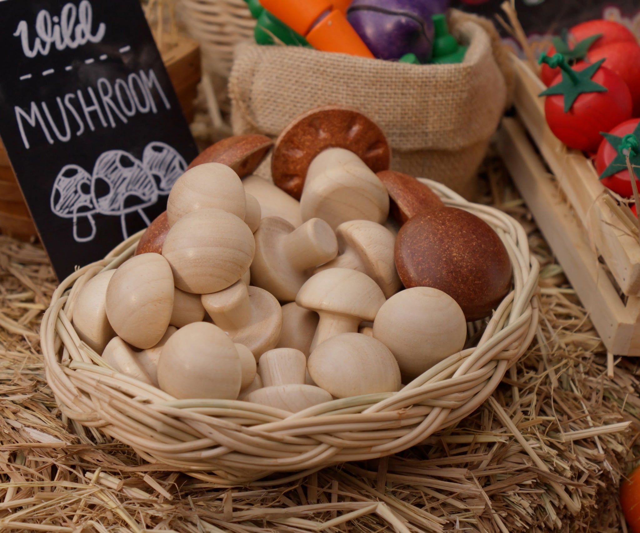 Wooden toy mushrooms from the Plan Toys Produce Set - a set of vegetable play food - in a rattan basket.