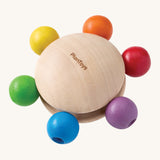 Plan Toys Pull & Grasp wooden baby toy - a wooden disk with rainbow grasping beads.